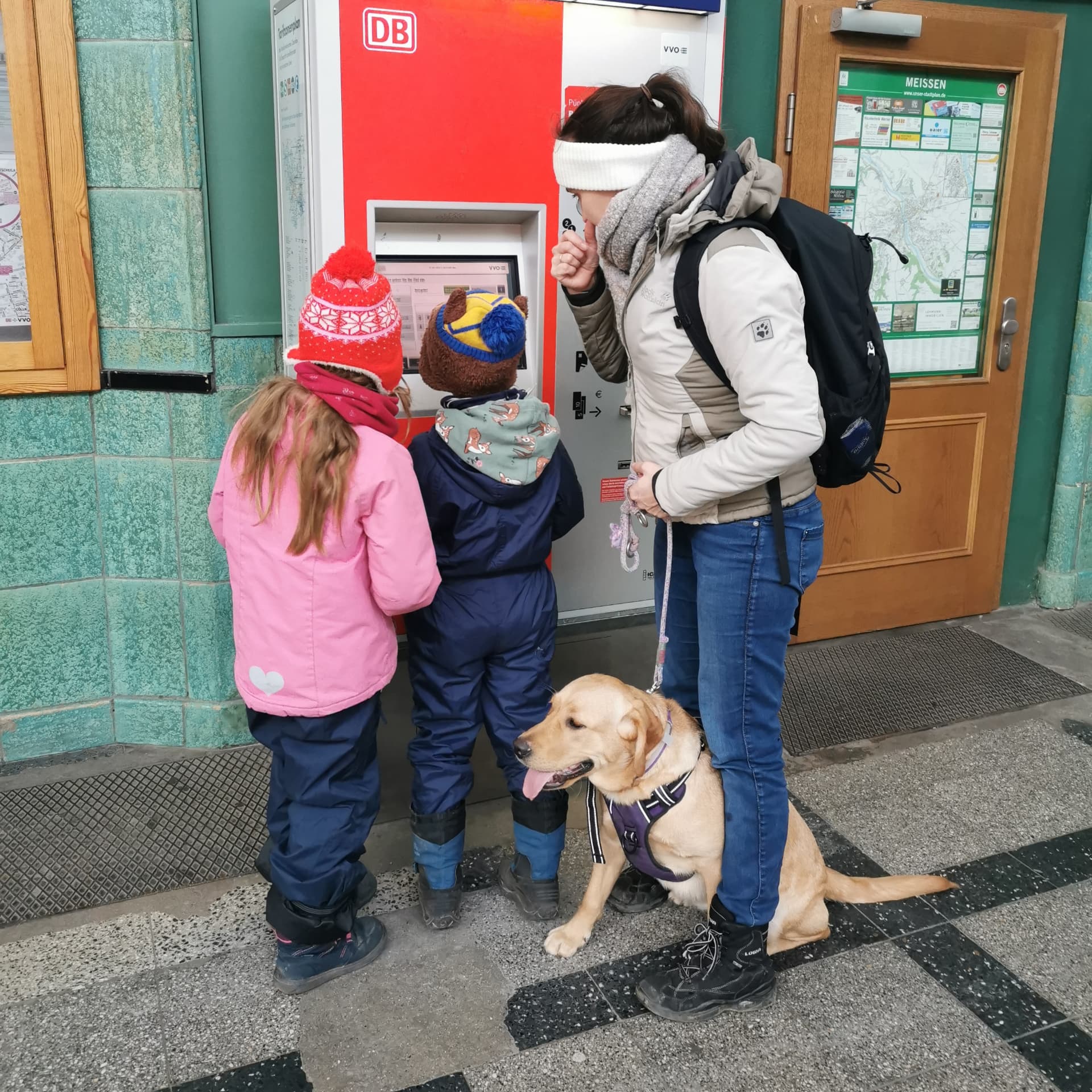 Hund wartet entspannt am Fahrkartenautomat