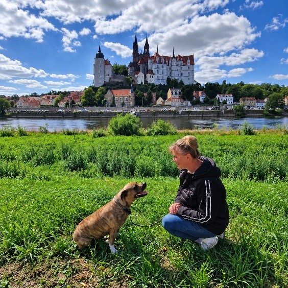 Tina Linge mit Hund auf der Elbwiese vor der Albrechtsburg Meißen